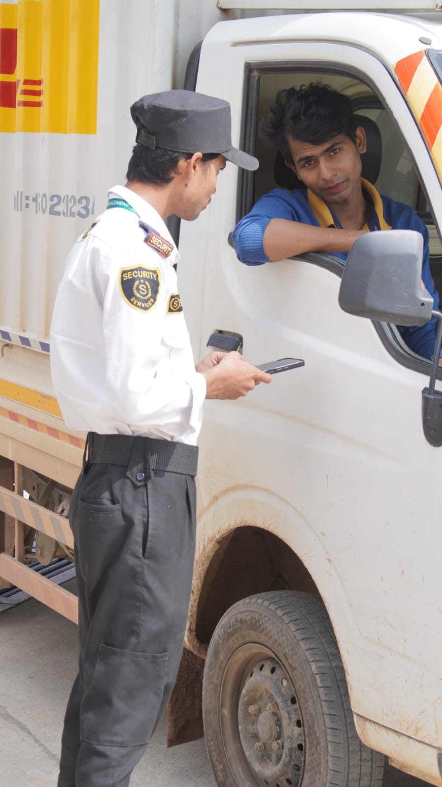 Goods vehicle screening &mdash; Driver and consignment verification at a service entrance.